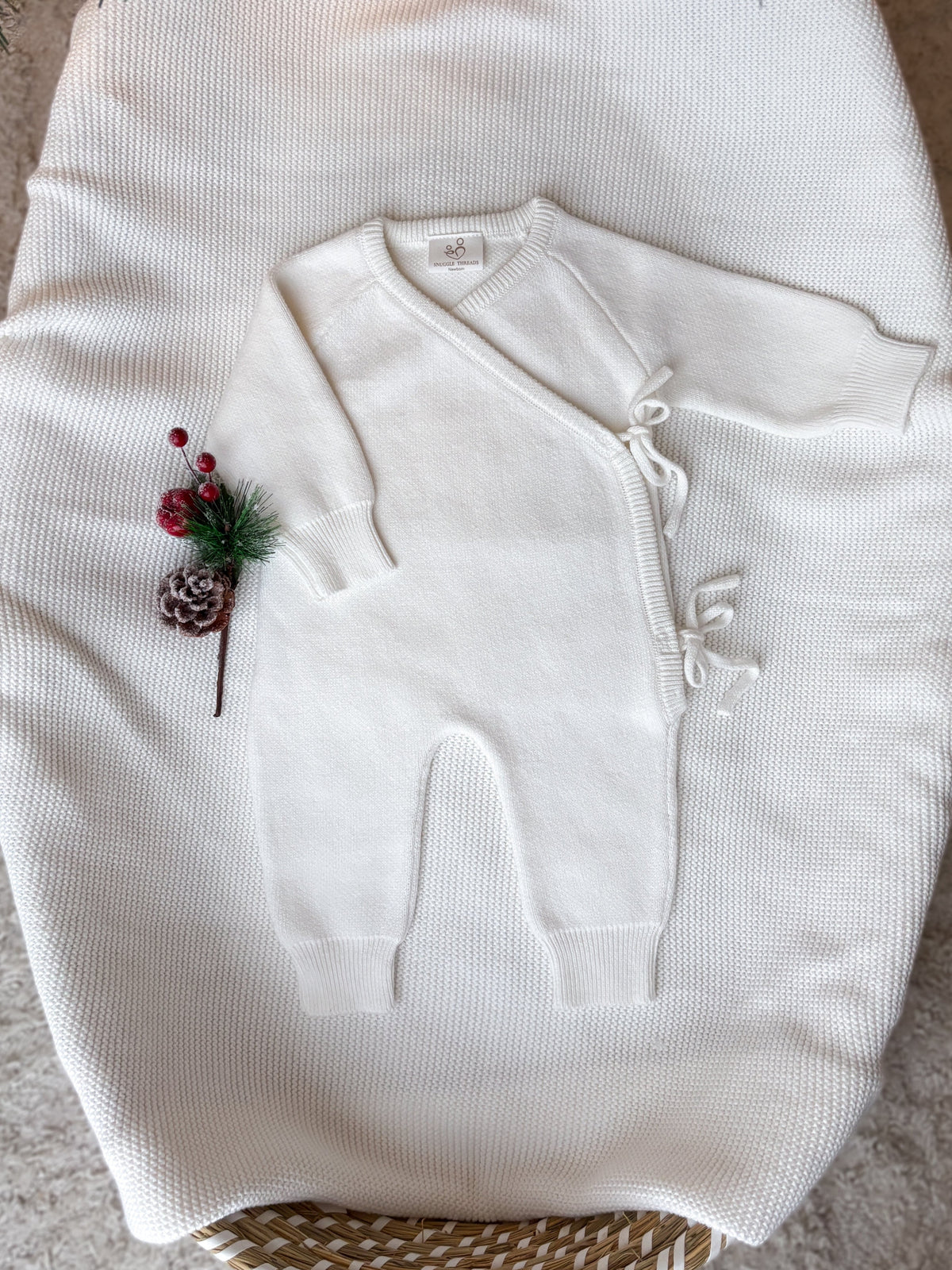 Ivory knitted baby wrap romper with long sleeves, side tie fastenings and a blank front ready for personalised embroidery