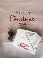Ivory knitted baby wrap romper with red My First Christmas embroidery, displayed on a matching personalised Christmas baby blanket with 2026 design.
