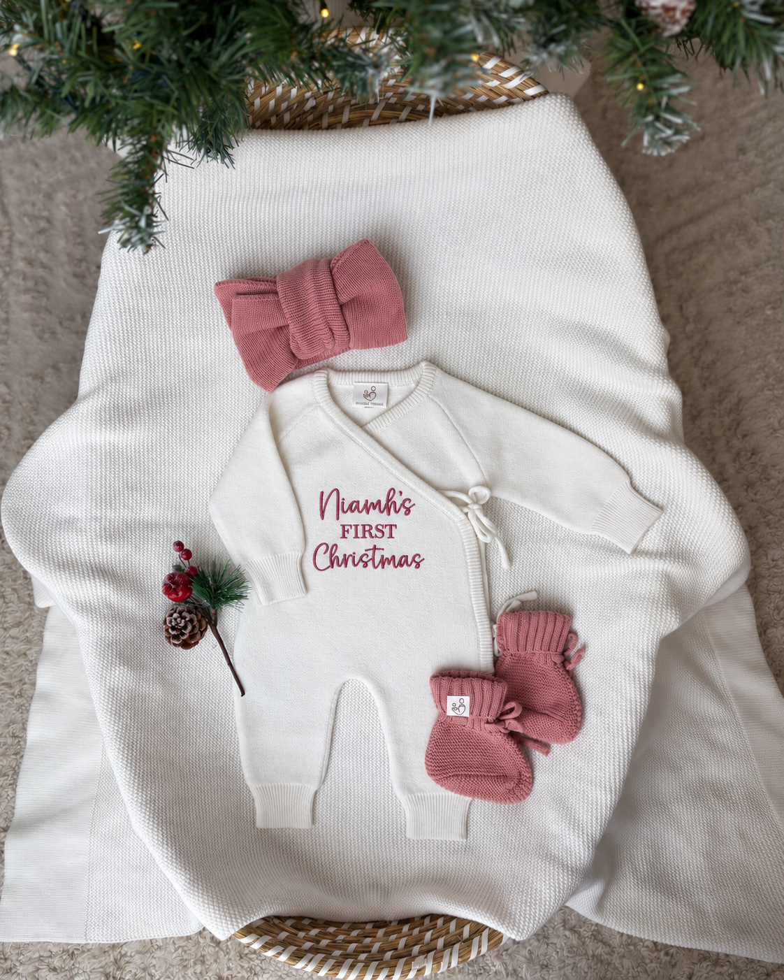 Personalised ivory baby's first Christmas knitted wrap romper with custom name embroidery, dusty pink headbow and booties