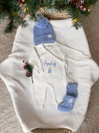 Personalised ivory Christmas baby wrap romper with custom name and blue Christmas tree embroidery, matching blue knitted hat and booties