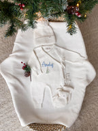 Personalised ivory knitted Christmas baby wrap romper with custom name and Christmas tree embroidery, matching ivory hat and booties