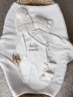 Personalised Hello World baby wrap romper with ivory knitted hat, baby booties and headbow