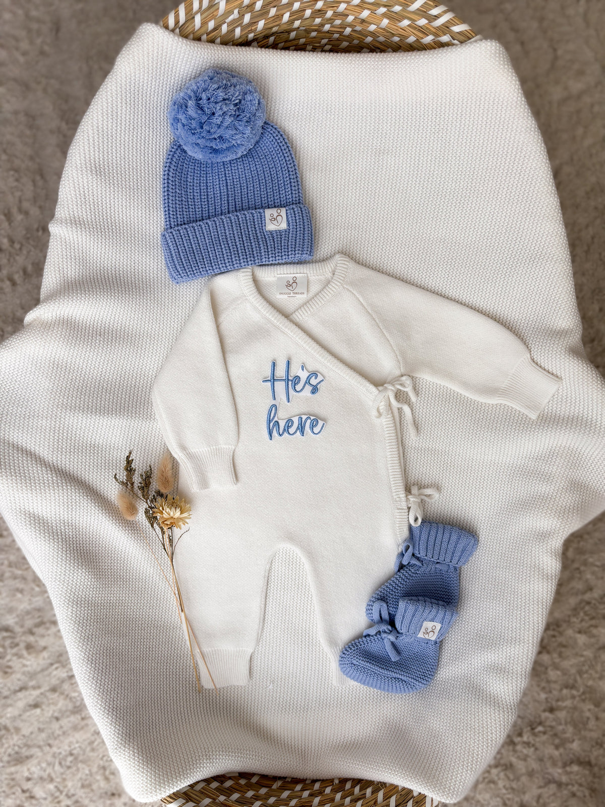 Personalised He's Here baby wrap romper with blue knitted hat and baby booties
