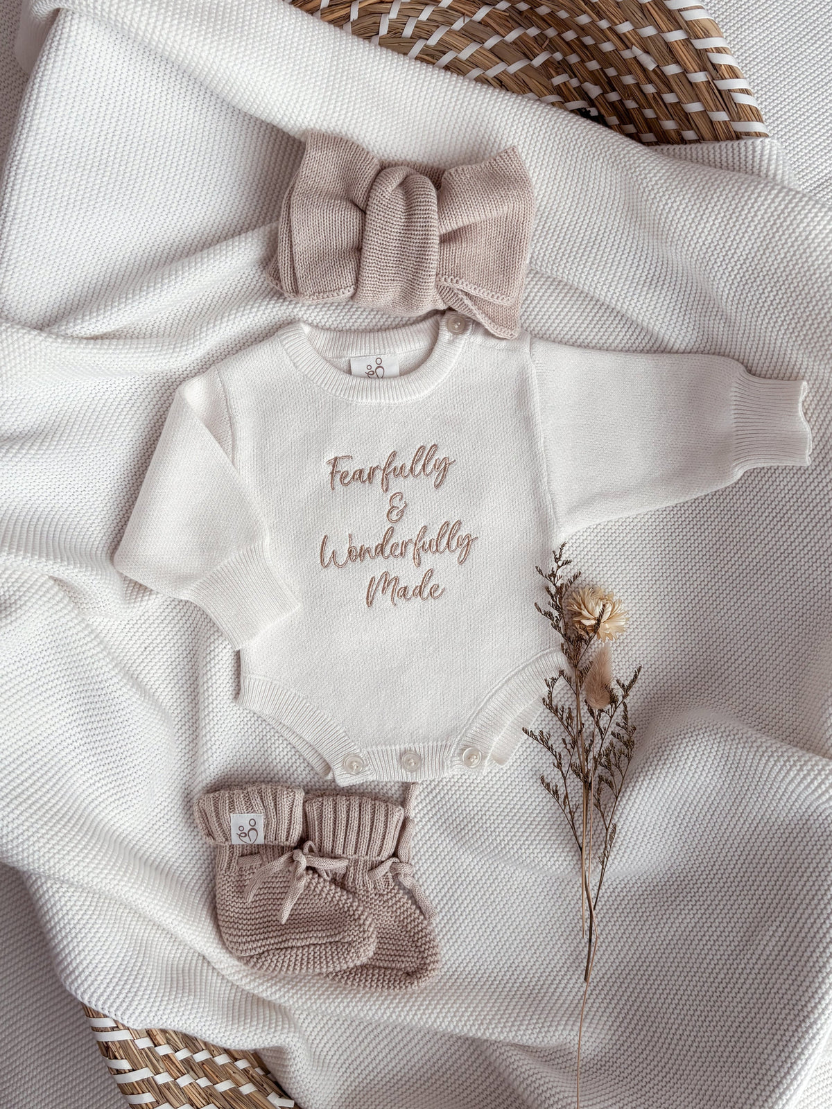 Personalised ivory baby romper with beige embroidery, matching knitted headband and booties