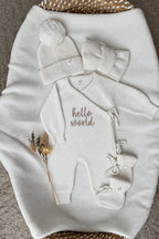 Personalised ivory wrap baby romper with neutral embroidery, matching knitted hat, headband and booties