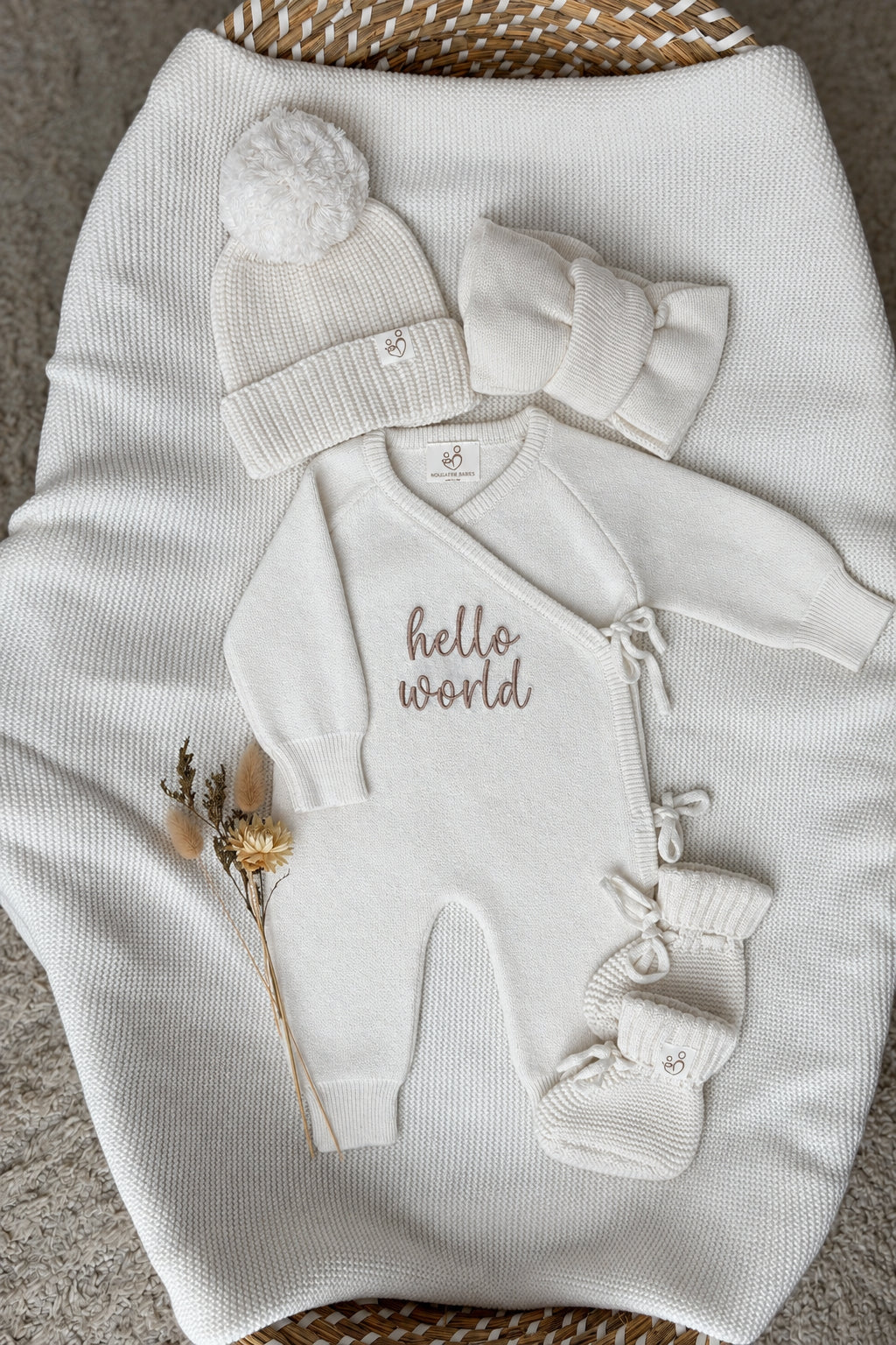 Personalised ivory wrap baby romper with neutral embroidery, matching knitted hat, headband and booties