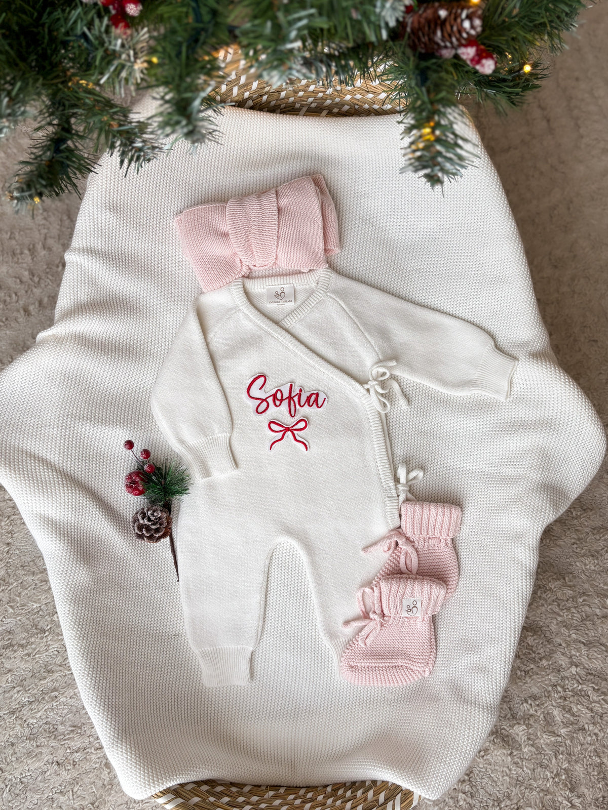 Personalised Christmas wrap romper with name and bow design, pink knitted baby booties and headbow