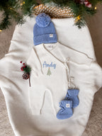 Personalised Christmas wrap romper with name and Christmas tree design, blue knitted hat and baby booties