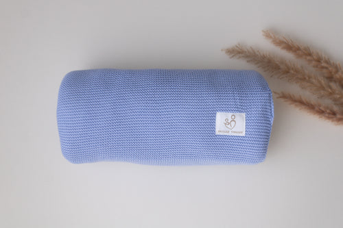 Folded baby blue knitted cotton baby blanket with textured knit, ribbed edging and Snuggle Threads woven label.
